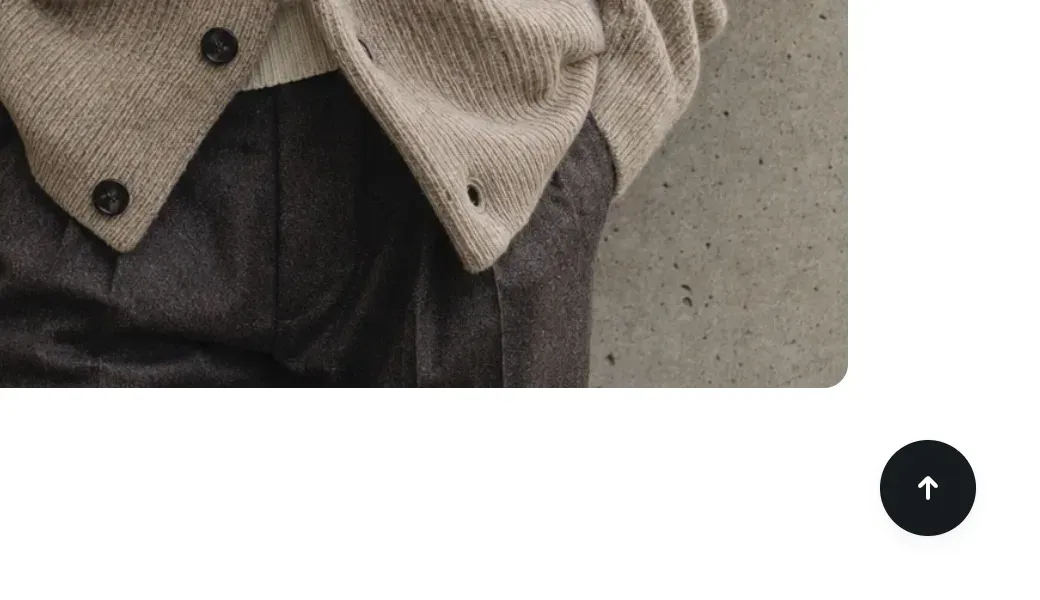 Round dark back to top button with an up arrow in the bottom-right corner of the page.