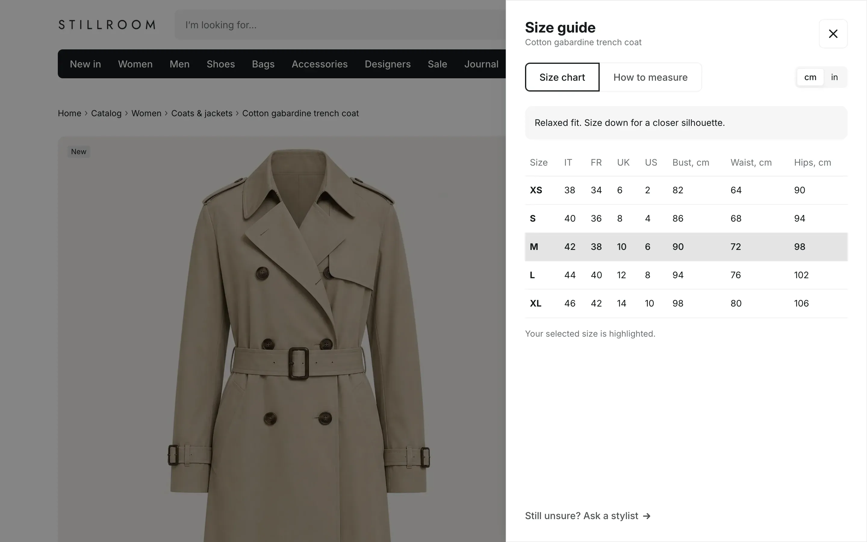 Size guide panel open over a product page: the title Size guide with the product name, Size chart and How to measure tabs, a cm and in switch, a fit note, and a size table with columns Size, IT, FR, UK, US, Bust cm, Waist cm and Hips cm. The M row is highlighted, with the note Your selected size is highlighted, and a Still unsure? Ask a stylist link at the bottom.